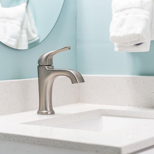 A modern bathroom sink with a sleek silver faucet and white countertop. A white towel hangs on a ring against a light blue wall.